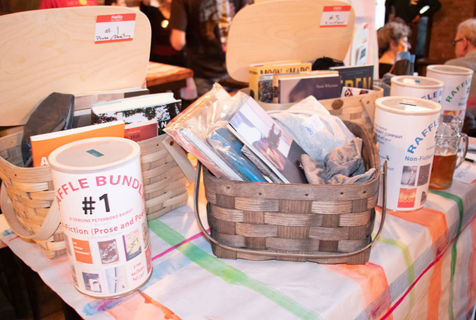 A table filled with giveaway items. Some are in baskets. There is a plaid tablecloth underneath