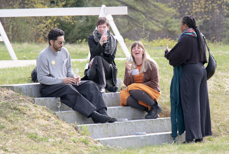 MacDowell Fellows gather together on the stone steps leading to the field at the New Hampshire Benefit in May 2022