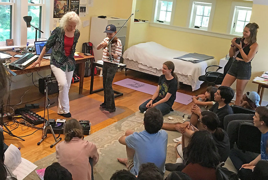 Fellow Martha Mooke hosts a group of students in her studio. One of the students is playing her violin