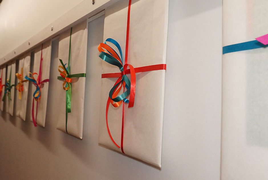 Works of art wrapped in white paper and tied up with colorful ribbons on display at the 2019 New Hampshire Benefit