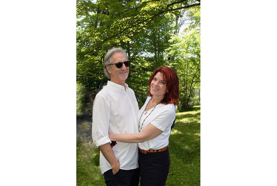 Roseanne Cash and John Leventhal embracing and smiling for the camera
