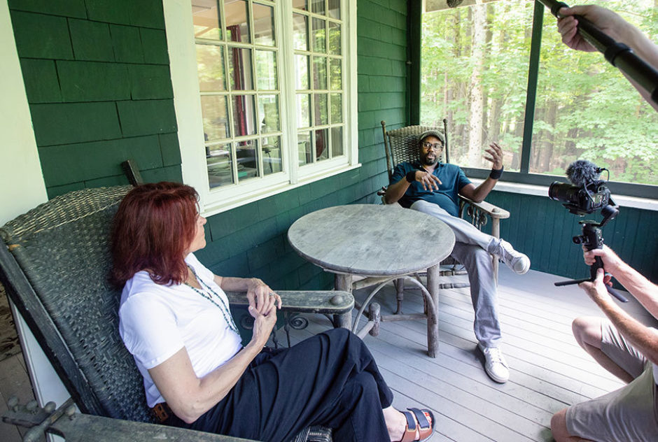 Roseanne Cash sitting on a porch and having a conversation with a Fellow  during studio tours
