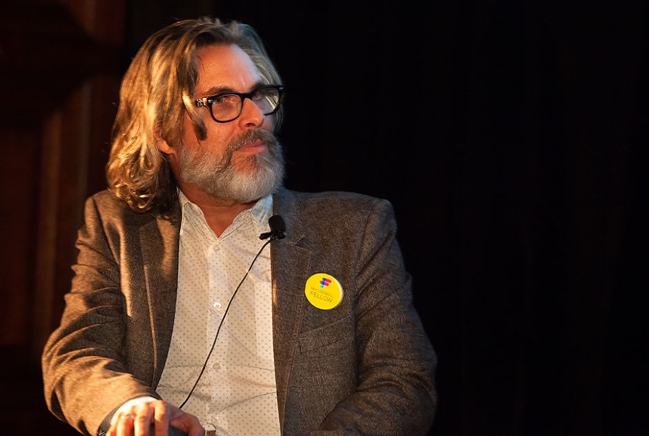 Michael Chabon, a microphone clipped to his shirt, sits on stage during the panel discussion