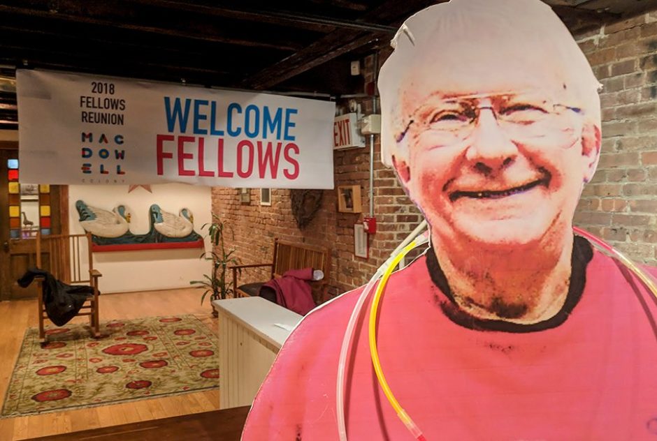 The decorated entrance to the party. A live-sized cut-out of MacDowell staff member,  Blake Tewksbury greets attendees. A large banner that reads "Welcome Fellows" hangs in the back