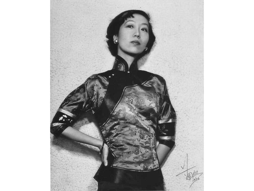 Portrait of Zhang Ailing. She is standing with her hands on her hips and looking into the camera