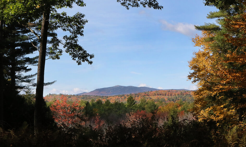 Mount Monadnock as viewed in autumn from MacDowell's amphitheater. Mostly clear sky, autumn colors in the foreground.