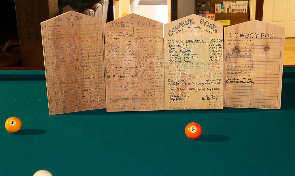 Wooden plaques known as the MacDowell Tombstones sitting on a pool table. The Tombstones are host to the names of Fellows that have stayed in the studio