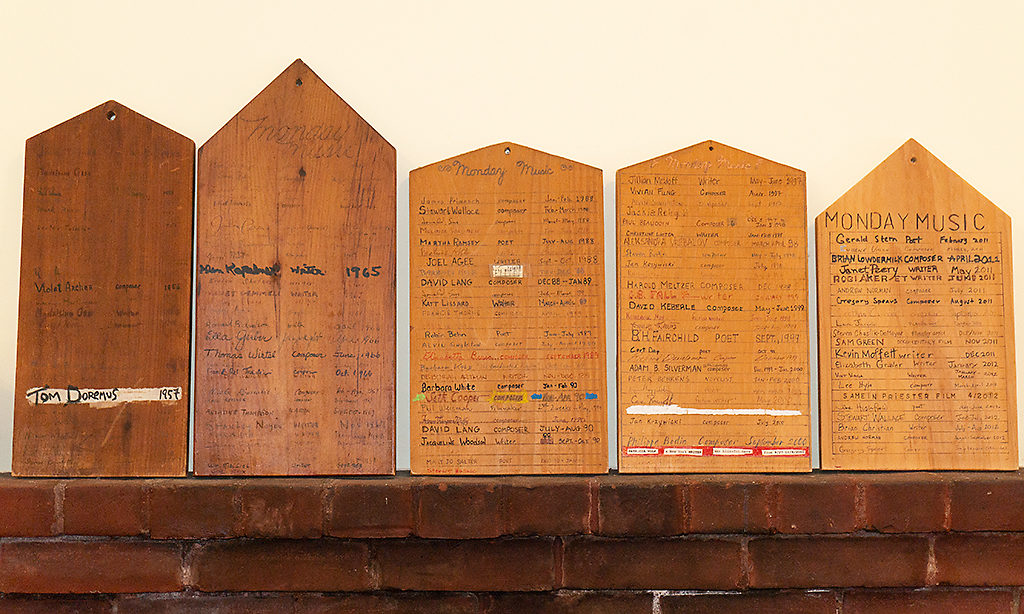 Wooden plaques known as the MacDowell Tombstones sitting on a ledge. The Tombstones are host to the names of Fellows that have stayed in the studio