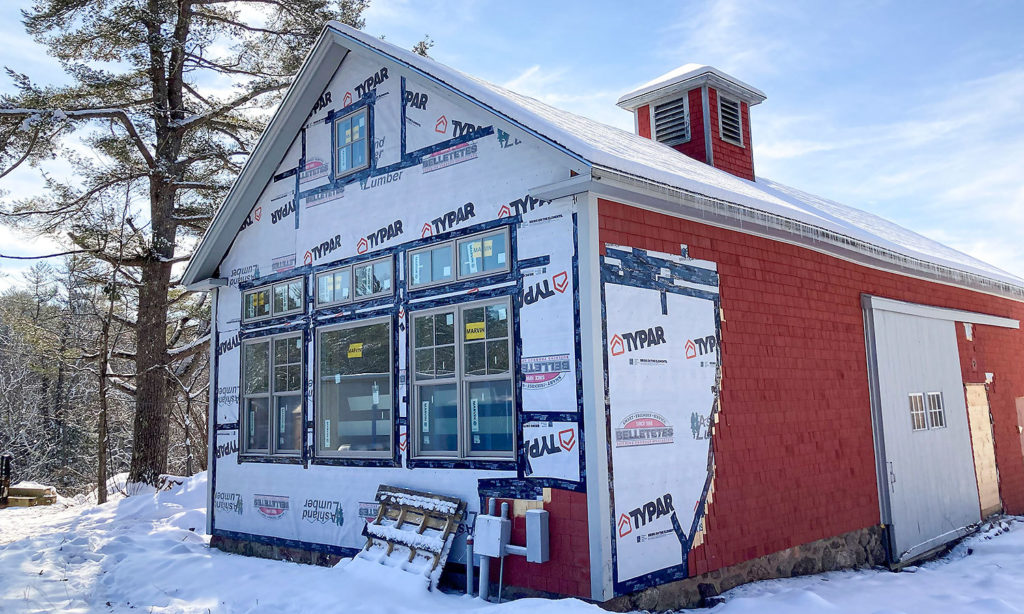 Exterior of Firth studio under renovation. The siding is in the process of being installed. It is snowy with blue skies.
