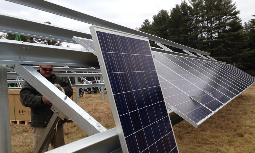Solar panels are being installed on large metal structures.