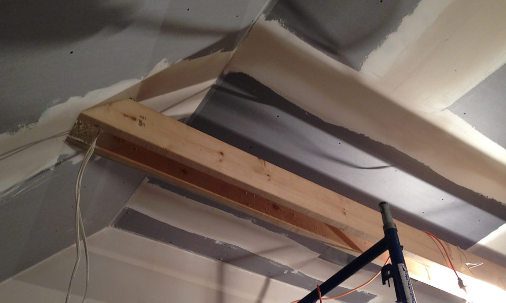 New rafters and sheet rock are installed in Delta Omicron studio. Wires hang from the ceiling.