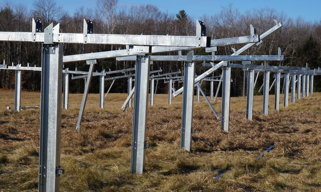 The metal structures for the new solar array are installed in a large field awaiting the installation of the solar panels