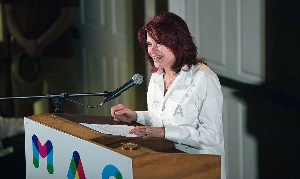 Roseanne Cash speaks at the podium during the Medal Day Ceremony