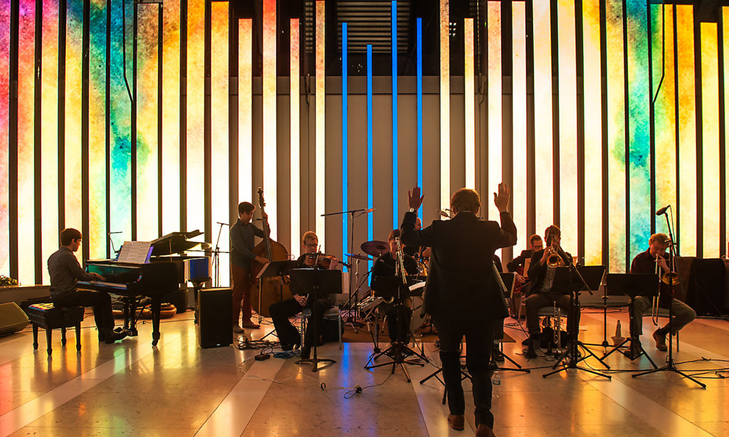 Chris conducts the jazz orchestra live as the animation plays on a large-scale video sculpture behind the musicians.