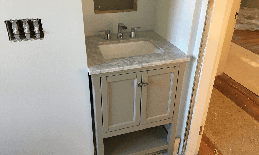 A new sink is fitted in one of the new water closets in the renovated building.