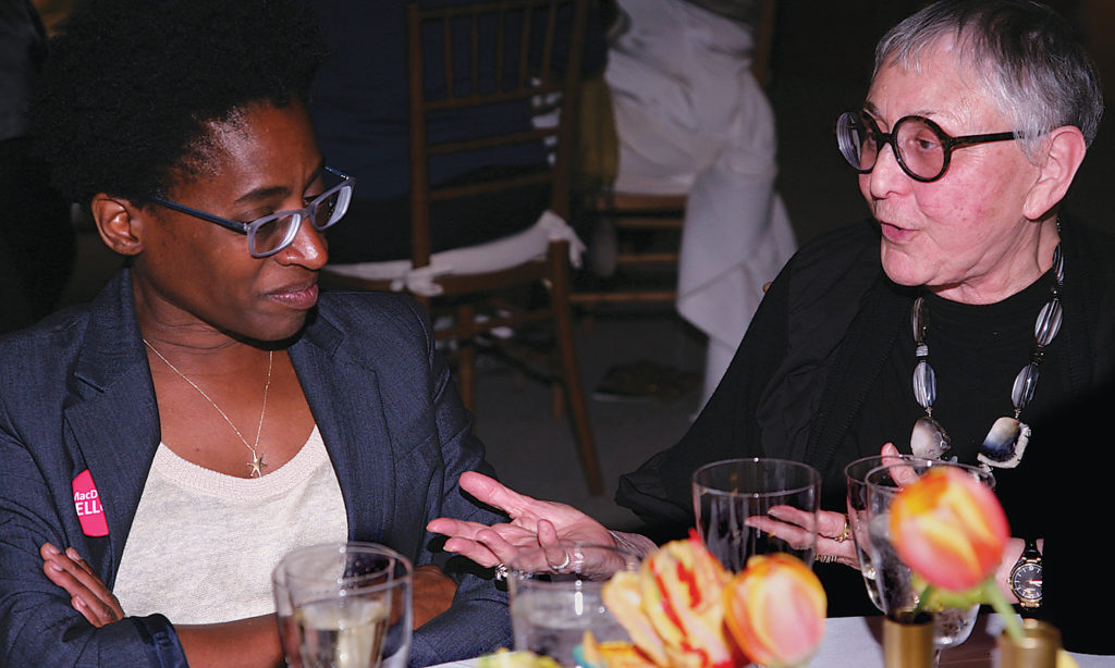Charlotte Sheedy, at right in the photo, makes a point to MacDowell Fellow Jacqueline Woodson at the National Benefit in New York City in May 2015. (Steven Tucker photo)