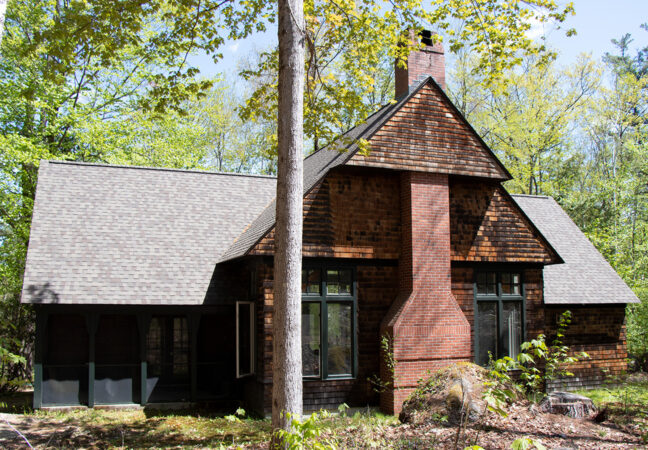 Nef studio in spring time. The large cedar-shingled building is set into a forest that is just beginning to get its leaves.