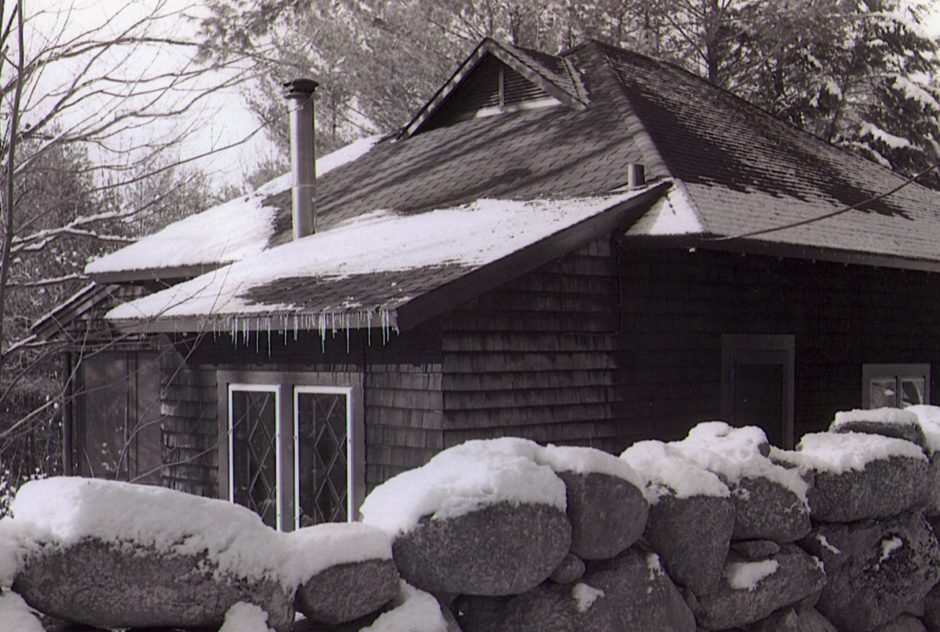 Black and white image of Cheney Studio in winter. A light snow and icicles cover the roof