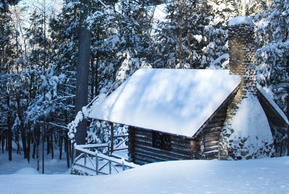 Log Cabin in winter surrounded by snow