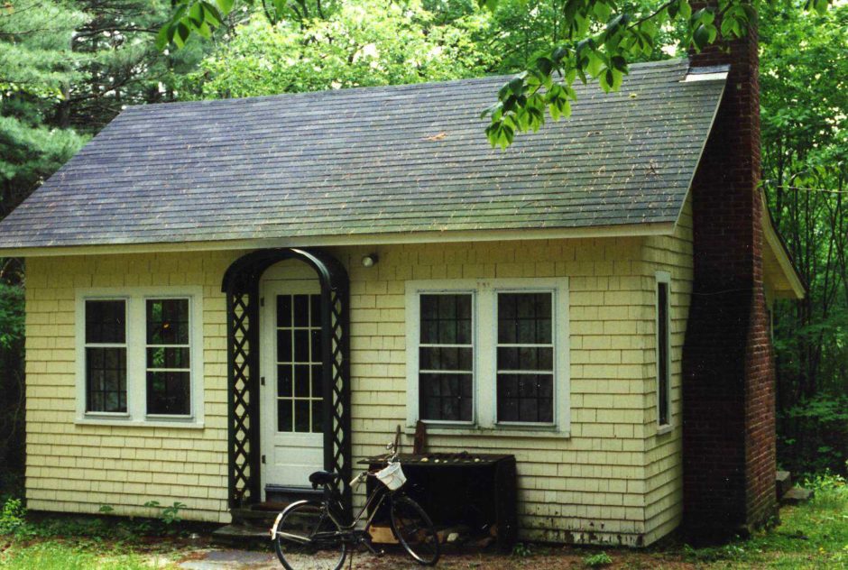 Mansfield Studio in summer surrounded by lush green forest. A bike rests out in front of the building.