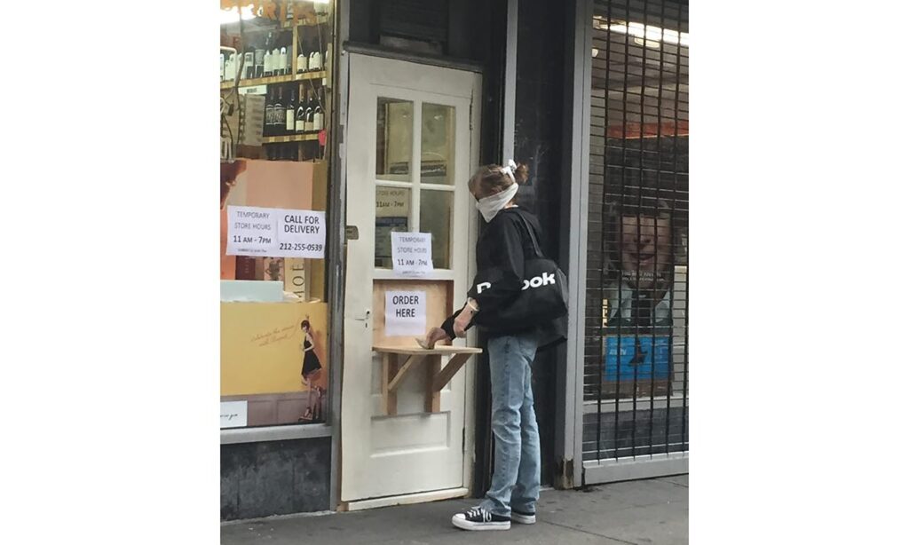 Closed store in New York with makeshift order counter attached to the door with the sign: "order here"