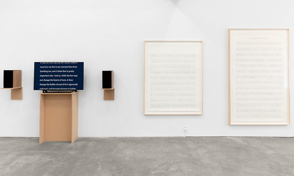 Manifestos 3 - Video (black and white and color, sound), Two graphite drawings on paper, one monitor, one pedestal, two speakers, hanging speaker shelves; dimensions vary; 2018