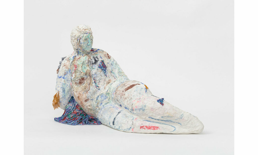 reclining figure sculpture made of plaster, fabric scraps and watercolor